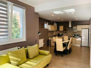 sala de estar con sofá amarillo y cocina en Luxury Modern Apartments, en Baia Mare