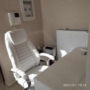 einen weißen Stuhl und einen Schreibtisch in einem Zimmer in der Unterkunft Athens, North Suburbs, Luxury Penthouse in Athen