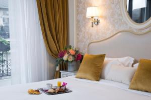 a hotel room with a bed with a tray of food on it at Hôtel Saint-Pétersbourg Opéra & Spa in Paris