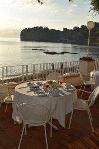 a table on a balcony with a view of the ocean at Hotel Lido Mediterranee in Taormina
