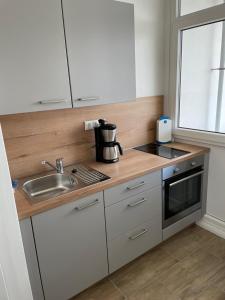 a kitchen with a sink and a counter top at City Weserblick in Bremerhaven