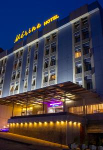 un bâtiment d'hôtel avec un panneau sur celui-ci la nuit dans l'établissement MERINA HOTEL, à Yaoundé