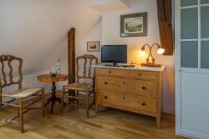 Zimmer mit einer Kommode mit einem TV und 2 Stühlen in der Unterkunft Romantisches Hotel zur Post in Brodenbach