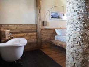 ein Badezimmer mit einer weißen Badewanne neben einem Bett in der Unterkunft Virasol in Dronero + 46 Fotos