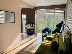 un salon avec un canapé vert et une télévision dans l'établissement Luxury Modern Apartments, à Baia Mare