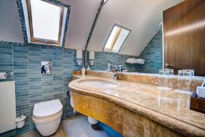 a bathroom with a large sink and a toilet at Hotel Usadba Primorsky Park in Alushta