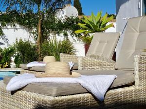 2 sillas de mimbre sentadas en un patio con toallas en VILLA OASIS SEA VIEW 3 bed PRIVATE HEATED POOL - La Cala de Mijas by Solrentspain en Mijas Costa