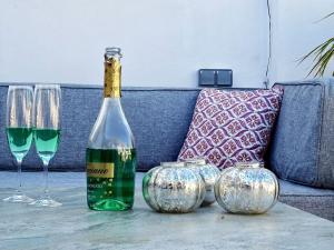 una bottiglia di vino seduta su un tavolo con due bicchieri di VILLA OASIS SEA VIEW 3 bed PRIVATE HEATED POOL - La Cala de Mijas by Solrentspain a Mijas Costa