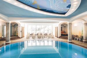a swimming pool with a ceiling with an aquarium at Hotel Enzian - Adults Only in Obertauern