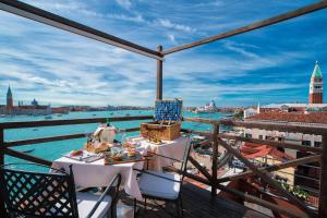einen Balkon mit einem Tisch und Stühlen sowie Stadtblick in der Unterkunft Londra Palace Venezia in Venedig