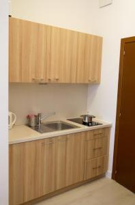 a kitchen with wooden cabinets and a sink at Trzy Wyspy Apartments - Aquamarina in Świnoujście