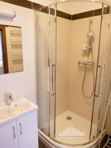 a bathroom with a shower and a sink at Trzy Wyspy Apartments - Aquamarina in Świnoujście