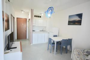eine Küche und ein Esszimmer mit einem Tisch und Stühlen in der Unterkunft BA - Cristallo - Sea View - in Lignano Sabbiadoro