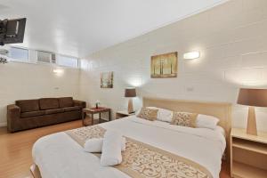 a large bedroom with two beds and a couch at Gazebo Motor Inn in Strathmerton