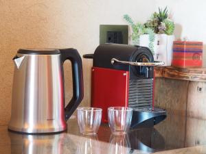 Eine Kaffeemaschine stand auf der Theke neben zwei Gläsern. in der Unterkunft Virasol in Dronero