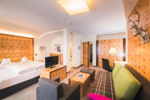 a hotel room with a bed and a tv at Hotel Enzian - Adults Only in Obertauern
