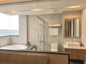 een badkamer met een bad, een douche en een wastafel bij Dream Summer Hotel in Magong