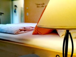 a close up of a bed with a lamp on it at Ferienwohnung A Casa Mia in Gengenbach
