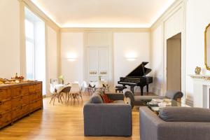 uma sala de estar com um sofá e um piano em Divisi Suites & SPA em Palermo