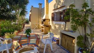 a patio with a table and chairs and a stove at CASA SHERA in Sant Josep de Sa Talaia