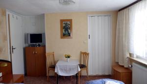 Habitación con mesa, sillas y TV. en FEWO Angelika DG, en Rohrbach