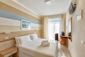 una camera d'albergo con letto e scrivania di Hotel La Residenza a Riccione
