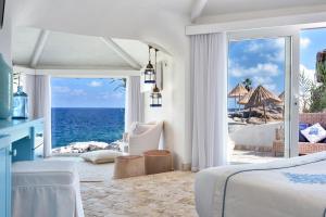 a bedroom with a view of the ocean at Arbatax Park Resort - Dune in Àrbatax