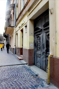 利沃夫Dorosh-HOME квартира-студія в центрі Львова的沿着建筑物旁边的街道走的人