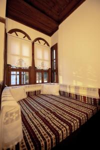 a large bed in a room with two windows at KÜRKÇÜ KONAK in Safranbolu