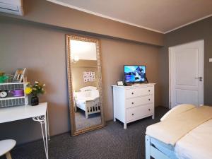 a bedroom with a mirror and a bed and a dresser at Sudului 810 by MRG Apartments - Spitalul Bagdasar - Spitalul Obregia in Bucharest