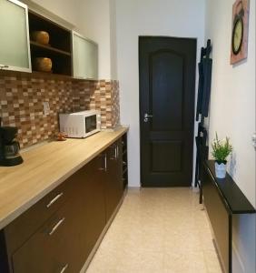a kitchen with a counter with a microwave and a door at Sudului 810 by MRG Apartments - Spitalul Bagdasar - Spitalul Obregia in Bucharest