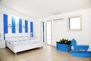 a blue and white bedroom with a bed and a blue chair at La stella di Montalbano con parcheggio privato in Punta Secca