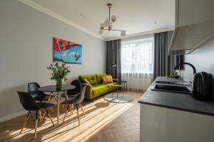 a kitchen and living room with a green couch at Wonderful Apartment In The Heart Of Kaunas Center in Kaunas