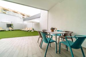 ein Esszimmer mit einem Tisch, Stühlen und einem grünen Teppich in der Unterkunft Ocean Garden Suite 11 con jardín privado in Adeje