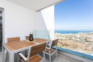 een eetkamer met een tafel en stoelen en een groot raam bij Ocean Garden Suite 12 in Adeje