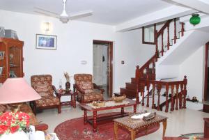 a living room filled with furniture and a staircase at Leelu Homestay in Cochin