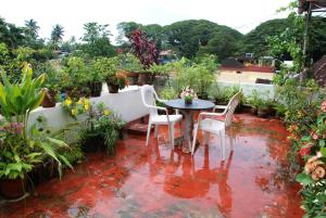eine Terrasse mit Tisch, Stühlen und Pflanzen in der Unterkunft Leelu Homestay in Kochi