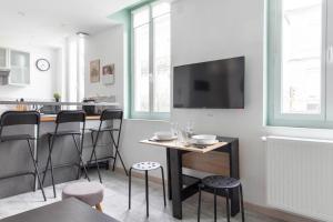 a living room with a table and chairs and a tv at Le RI-BELLOT de 1 à 4 pers - Lit King Size in Cognac