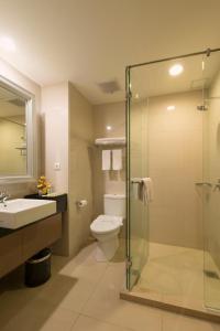 a bathroom with a toilet and a glass shower at Pranaya Boutique Hotel in Serpong