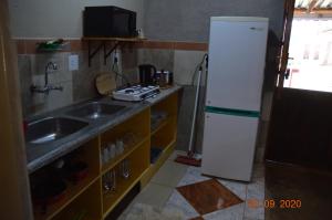 La cuisine est équipée d'un évier et d'un réfrigérateur blanc. dans l'établissement DE OUDE STOOR, à Koster