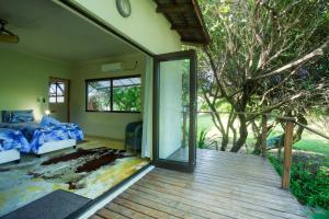 a bedroom with a bed and a sliding glass door at Baleia Azul 26 in Ponta Mamoli