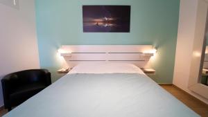 バルレッタにあるLa Palma Del Solのベッドルーム(白いベッド1台、黒い椅子付)