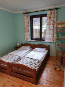 2 camas individuales en una habitación con ventana en Gościniec Skalite, en Godziszka