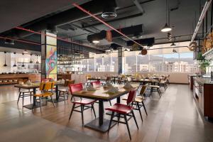 a restaurant with tables and chairs in a room at Wyndham Garden Muscat Al Khuwair in Muscat