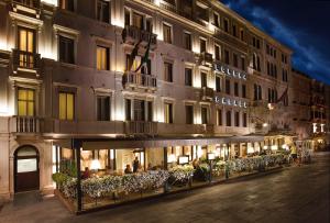 a facade of a hotel at night with lights at Londra Palace Venezia in Venice