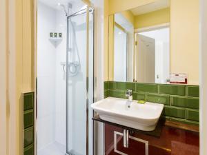 y baño con lavabo y ducha. en The Portland Guesthouse, en Cheltenham