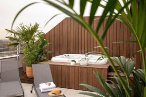 a bathroom with a tub on a balcony with plants at Hôtel du Port in Nogent-sur-Marne