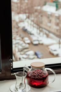 a glass jar filled with cranberries next to a window at Гостиница Мелисса in Stavropol