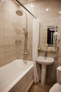 een badkamer met een bad, een wastafel en een toilet bij Гостиница Мелисса in Stavropol
