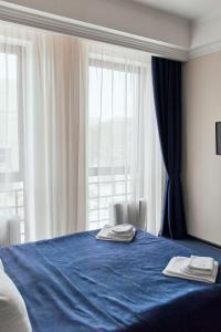 een slaapkamer met een blauw bed met 2 handdoeken erop bij Гостиница Мелисса in Stavropol